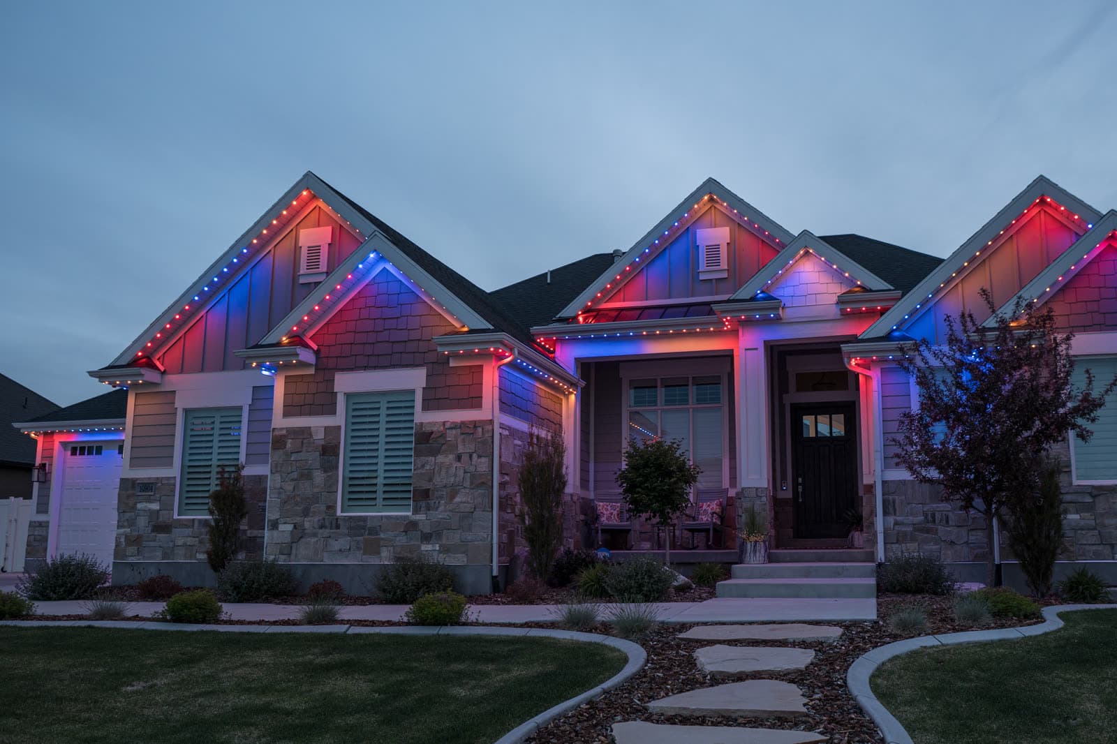 Home illuminated with red and blue permanent game-day lighting